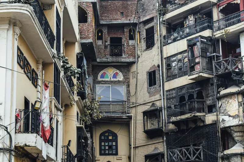 Densely packed older residential buildings with balconies and added upper storeys, typical of inner-city Lahore neighbourhoods.