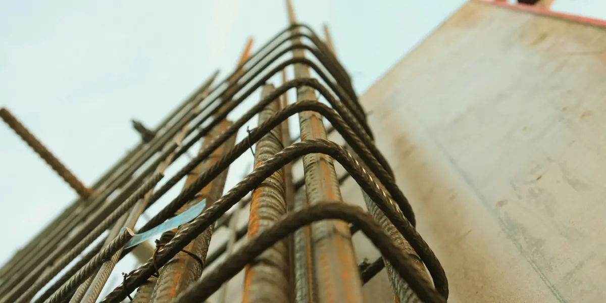 Close view of tied steel reinforcement bars projecting from a concrete member, seen against the sky.